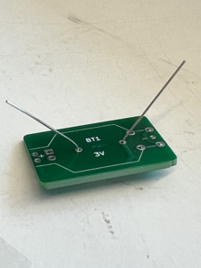 On the opposite side of the board, bend the leads of the resistor outwards so that it can't move.